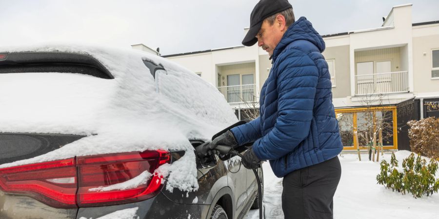 mann steckt plug-in-hybrid ein