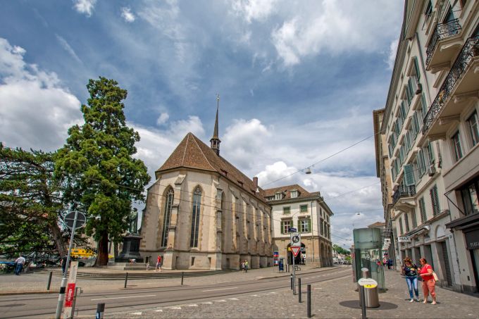 Auf dem Friedhof der Wasserkirche in Zürich liegt eine berühmte Schweizer Persönlichkeit begraben: der Reformator Ulrich Zwingli. Strasse Kirchengebäude Bäume Fussgänger