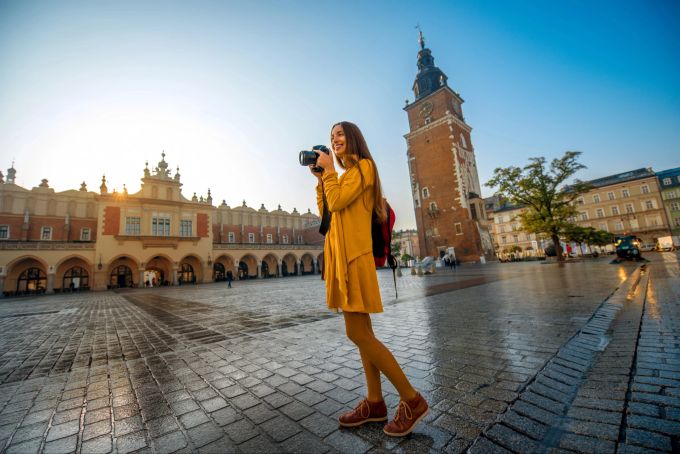 Krakau ist vor allem für den mittelalterlichen Marktplatz bekannt. Touristin mit Kamera in Krakau