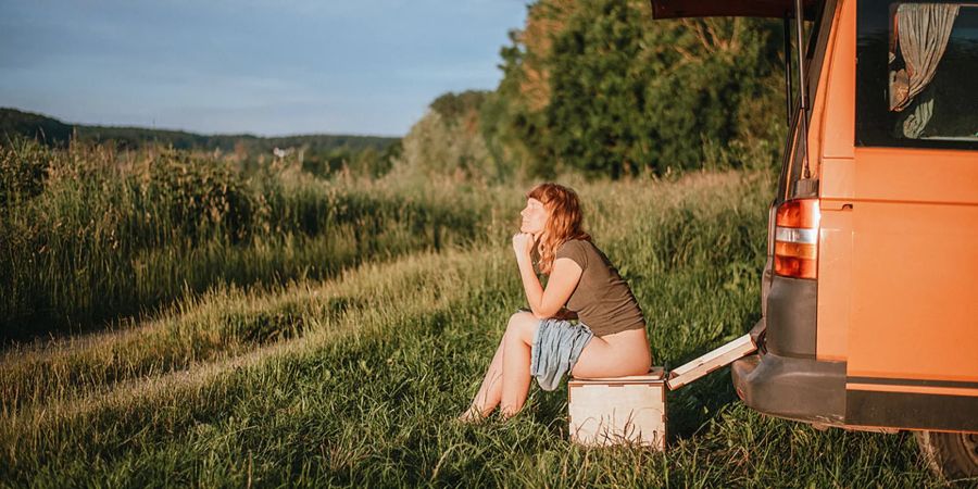 Frau Trockentrenntoilette Bulli im Hintergrund Natur