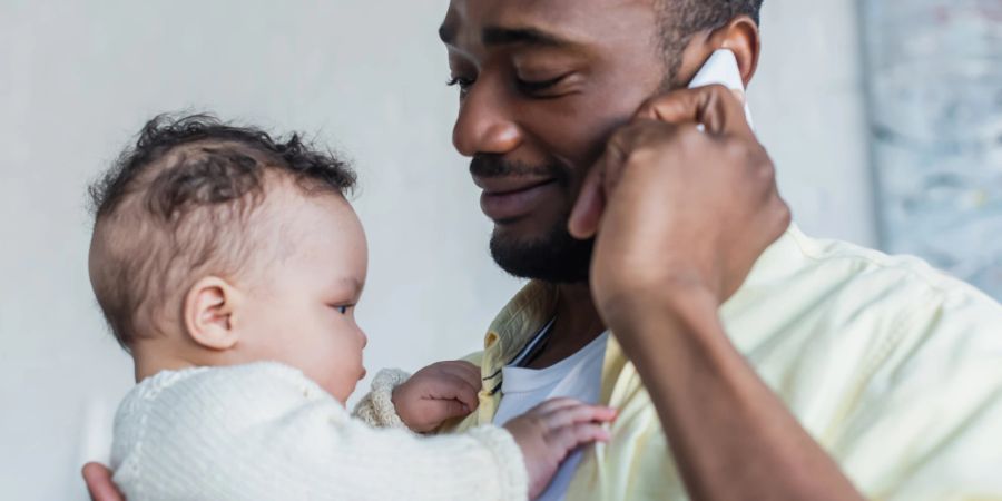 Mann mit Baby und Smartphone