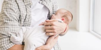 Schlafendes Baby auf dem Arm des Vaters