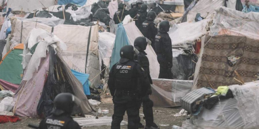 dpatopbilder - Bereitschaftspolizisten stehen während der Räumung zwischen den Unterkünften des provisorischen Migrantenlagers am Strand «El Trampolin» in Ceuta. Foto: Fabian Suspe...