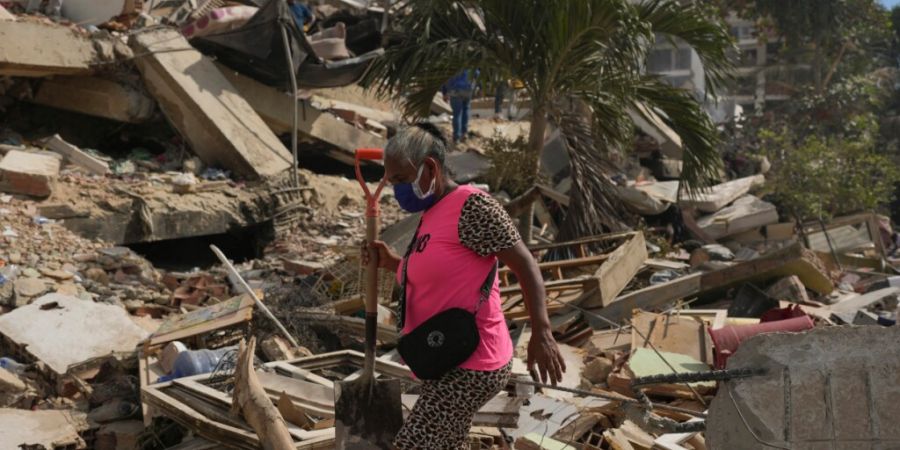 Anwohner durchsuchen die Trümmer eines Gebäudes in La Guaira. Foto: Matias Delacroix/AP/dpa