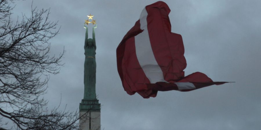 ARCHIV - Eine lettische Fahne weht am Freiheitsdenkmal. Foto: Alexander Welscher/dpa