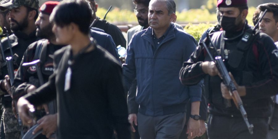 ARCHIV - Sicherheitsbeamte eskortieren den pakistanischen Innenminister Mohsin Naqvi (Mitte), der zu einem Gespräch mit den Medien über die aktuelle Situation zu den Zusammenstößen ...