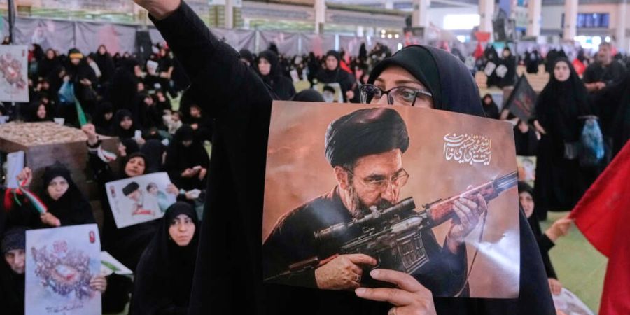ARCHIV - Eine Frau hält ein Plakat des iranischen Obersten Führers Ajatollah Modschtaba Chamenei. Foto: Vahid Salemi/AP/dpa/Archivbild