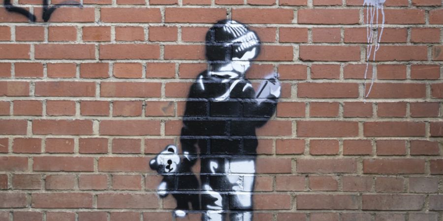 Dieses an die Werke des britischen Künstlers Banksy erinnernde Graffiti war am Freitag an der südöstlichen Ecke der Messehalle 2 in Basel zu sehen.