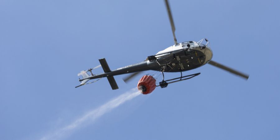 Weil das Feuer schon fast auf den Wald übergriff, boten die Einsatzkräfte einen Löschhelikopter auf. (Symbolbild)