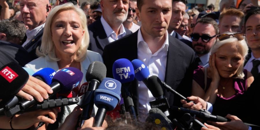 Marine Le Pen und Jordan Bardella stehen vor Journalisten. Foto: Michel Euler/AP/dpa/Archivbild