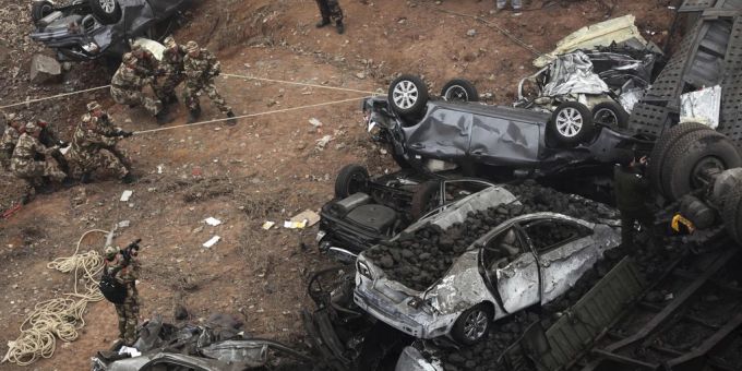 Chinesische Polizisten zerren Auto-Wracks nach einem Brückeneinsturz im Jahr 2013 beiseite. (Archivbild) china autobahnbrücke eingestürzt tote