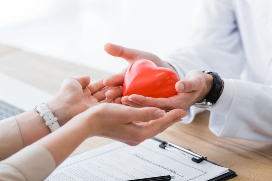 doktor und patientin mit herz in der hand