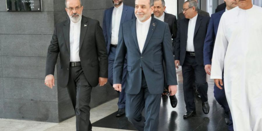 HANDOUT - Auf diesem vom iranischen Außenministerium über AP veröffentlichten Foto begibt sich der iranische Außenminister Abbas Araghtschi  (M) zum Ort der Gespräche zwischen dem ...