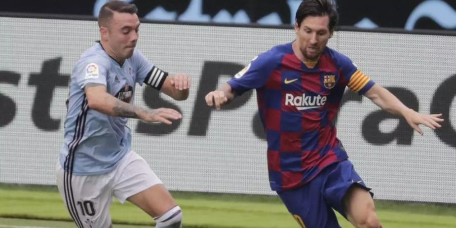 Lionel Messi (r) vom FC Barcelona behauptet den Ballbesitz gegen Celta Vigos Iago Aspas. Foto: Lalo Villar/AP/dpa