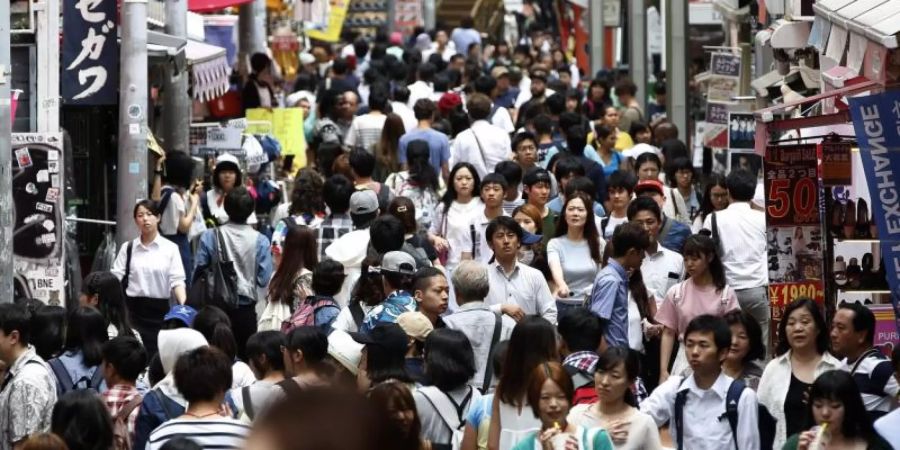 Menschen drängen sich auf einer Strasse der japanischen Hauptstadt. Foto: Yuya Shino/epa/dpa