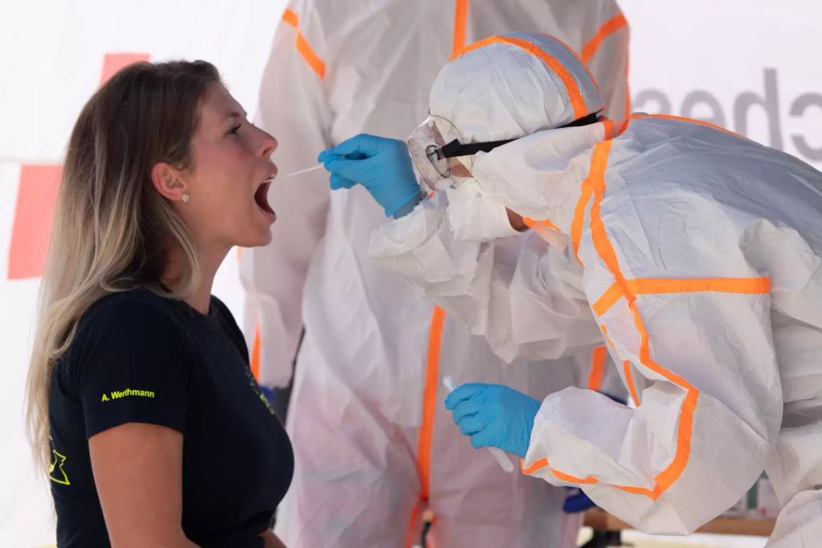 Eine Frau lässt sich mit einem Abstrichstäbchen auf das Coronavirus testen.