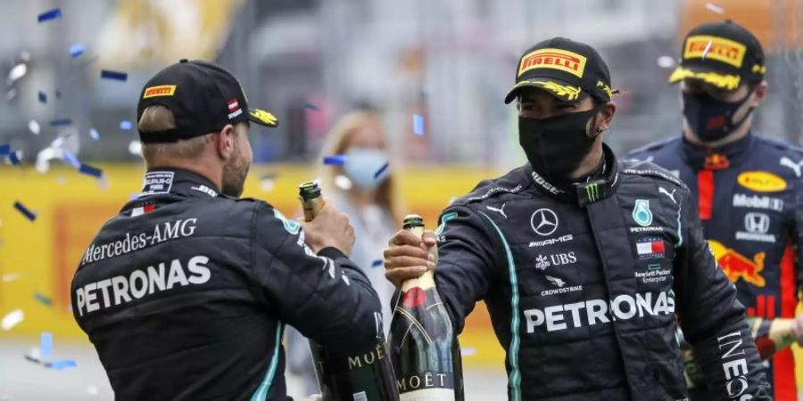 Hatten in Spielberg erneut Grund zum Feiern: Lewis Hamilton (r) und sein Mercedes-Teamkollege Valtteri Bottas. Foto: Leonhard Foeger/Pool Reuters/AP/dpa