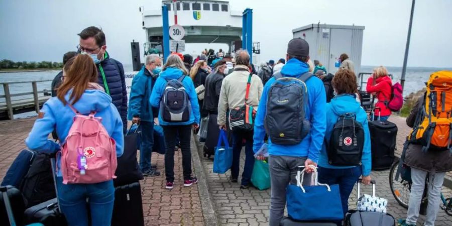 Urlauber warten im Hafen Schaprode auf Rügen auf die Überfahrt nach Hiddensee. Foto: Jens Büttner/dpa-Zentralbild/dpa