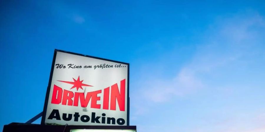 Das Schild eines Drive-In Autokinos leuchtet in der Nähe von Essen. Foto: Fabian Strauch/dpa