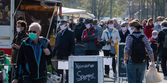 Besucher tragen auf dem Wochenmarkt wegen dem Coronavirus Schutzmasken. In der Schweiz kommt eine solche Pflicht nicht. Masken Coronavirus