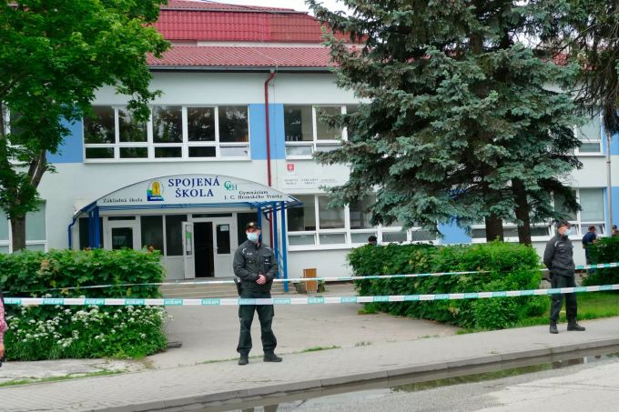 Polizeibeamte bewachen eine abgesperrte Grundschule, in der ein bewaffneter Mann mit einem Messer mehrere Menschen angegriffen hat. messerangrif schule slowakei Vrutky