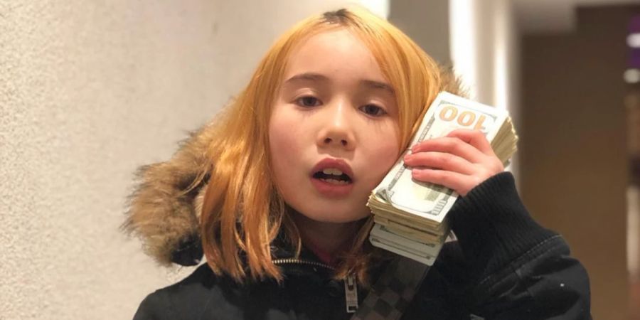 Lil Tay mit einem Bündel Geldscheine.