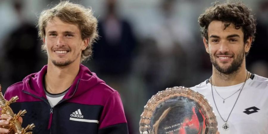 Madrid-Sieger Alexander Zverev (l) und der Zweitplatzierte Matteo Berrettini erhalten ihre Trophäen während der Siegerehrung. Foto: Bernat Armangue/AP/dpa