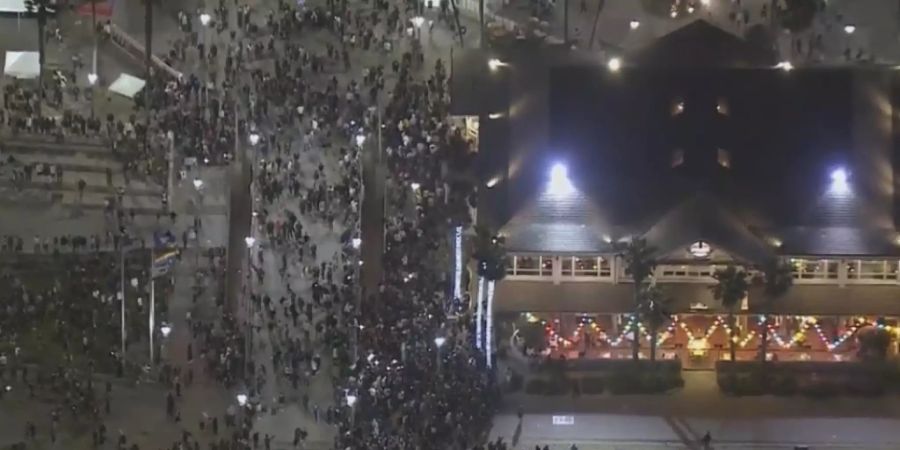 Menschen versammeln sich am Huntington Beach Pier in Kalifornien. Foto: Mark Rightmire/Fox 11 KTTV/AP/dpa