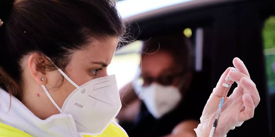 Eine Mitarbeiterin des Gesundheitswesens zieht in einem Drive-In-Impfzentrum am Outlet-Center von Valmonte eine Spritze mit einem Corona-Impfstoff auf. Foto: Mauro Scrobogna/LaPresse via ZUMA Press/dpa