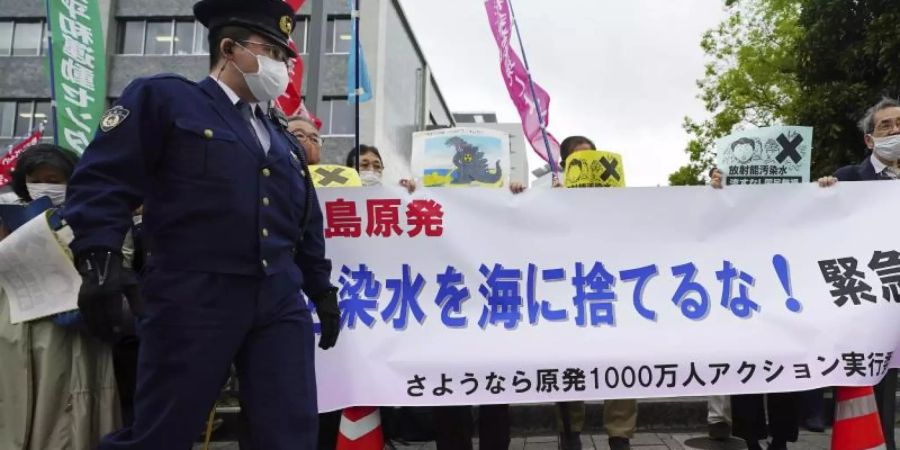 Menschen halten während einer Kundgebung vor dem Büro des Premierministers Suga ein Banner mit der Aufschrift «Werft kein radioaktives Wasser ins Meer». Foto: Eugene Hoshiko/AP/dpa