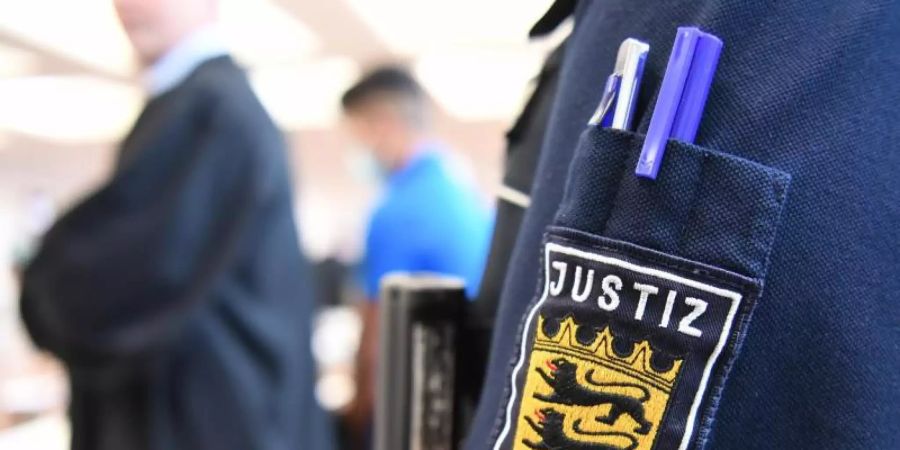 Im Hintergrund steht ein Angeklagter im Prozess vor dem Landgericht Ulm um die Vergewaltigung einer 14-Jährigen. Foto: Felix Kästle/dpa