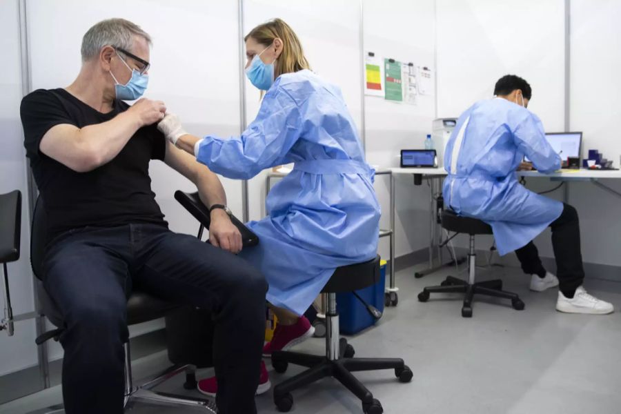 Ein Mann lässt sich im Impfzentrum Bernexpo gegen das Coronavirus impfen.