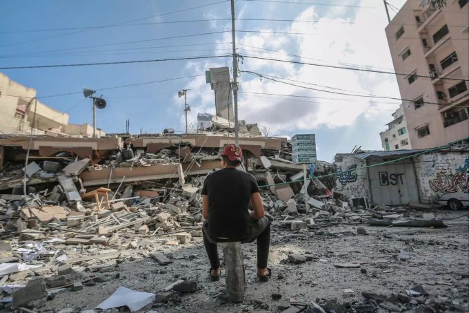 18.05.2021, Palästinensische Autonomiegebiete, Gaza-Stadt: Ein Palästinenser betrachtet die Trümmer eines zerstörten Wohnhauses, das bei israelischen Luftangriffen getroffen wurde. Konflikt in Nahost