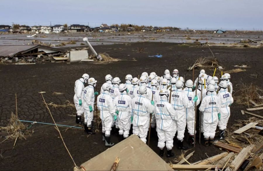 Japan erklärte die Zone 20 Kilometer um das Kernkraftwerk als «No-Go Zone». Polizisten in Schutzanzügen machen sich in dieser Zone auf die Suche nach Leichen.