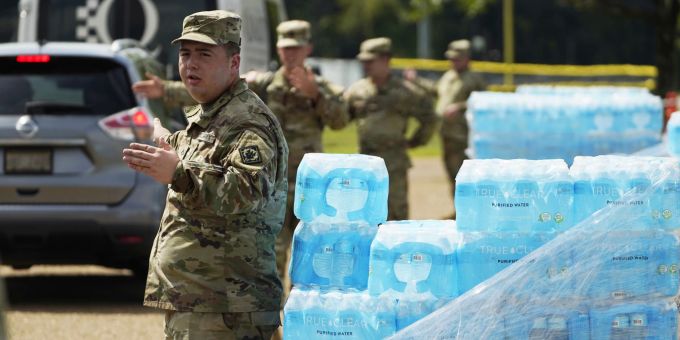 Soldaten der Nationalgarde von Mississippi leiten den Verkehr, während sie am Freitag, den 2. September 2022, im Smith Wills Stadium Kisten mit Trinkwasser an die Einwohner von Jackson, Mississippi, verteilen. Jacksons Wassersystem ist nach Überschwemmungen und heftigen Regenfällen, die langjährige Probleme in einer der beiden Wasseraufbereitungsanlagen verschlimmerten, teilweise zusammengebrochen, und der Staat hilft bei der Verteilung von Trinkwasser an die Einwohner der Stadt. Water Woes Mississippi