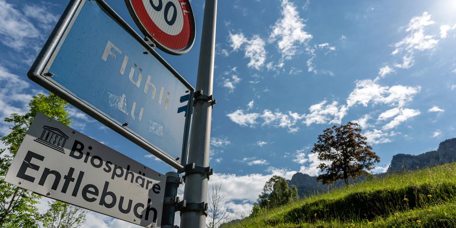 Ortstafel Flühli LU in der UNESCO Biosphäre Entlebuch. Hinten rechts die Schwändiflüh.