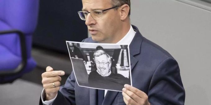 Michael Brand (CDU) hält bei seiner Rede im Bundestag ein Bild des ermordeten Kasseler Regierungspräsidenten Walter Lübcke. Foto: Christoph Soeder