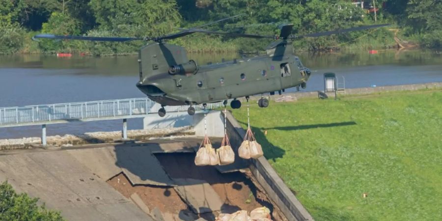 Ein Militärhubschrauber wirft Sandsäcke ab