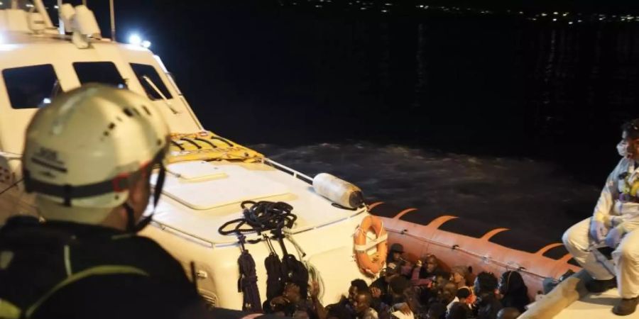 Migranten sitzen in einem Boot der italienischen Küstenwache, nachdem sie von Bord des Rettungsschiffs «Ocean Viking» gegangen sind. Foto: Renata Brito/AP