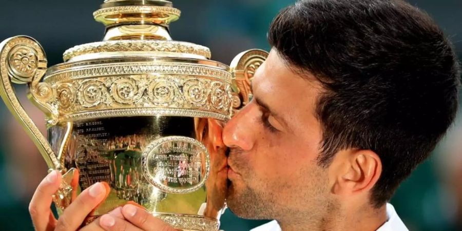 Novak Djokovic küsst bei der Siegerehrung die Trophäe für den Finalgewinner. Foto: Mike Egerton/PA Wire