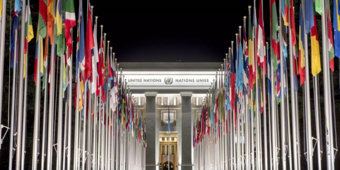 Flaggen verschiedener Nationen wehen auf dem Platz vor dem Palais des Nations im März 2016 Flaggen wehen vor einem Gebäude