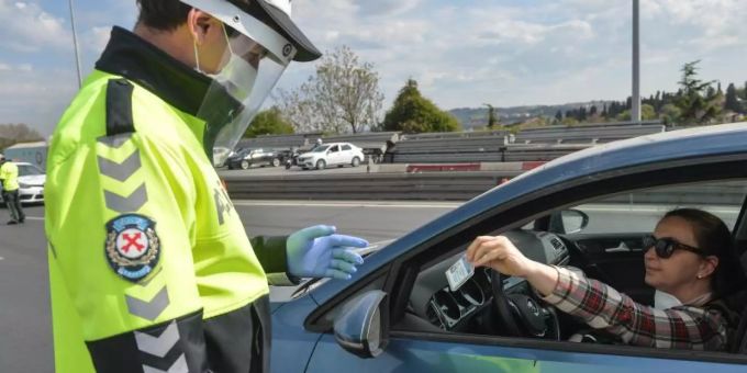 Ein Polizist kontrolliert in Istanbul eine Autofahrerin. Die Türkei will die bestehenden Beschränkungen schrittweise lockern. Coronavirus