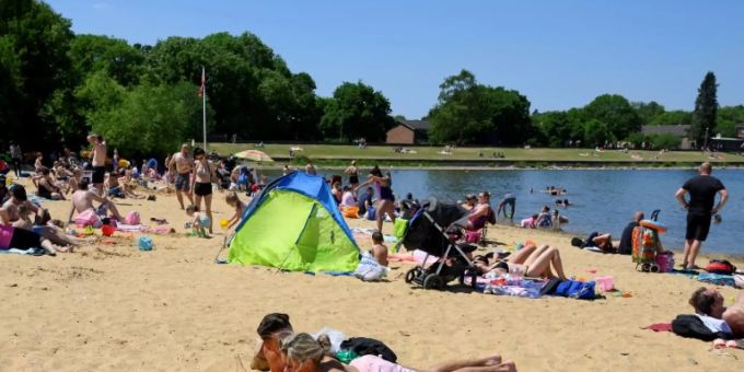 Menschen geniessen die ersten Sonnenstrahlen am Ruislip Lido in London Menschen geniessen die ersten Sonnenstrahlen am Ruislip Lido in London