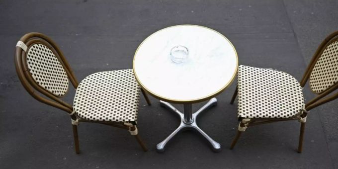 Ein Tisch mit zwei Stühlen steht auf der Töngesgasse in der Frankfurter Innenstadt vor einem Café. Foto: Arne Dedert/dpa Ein Tisch mit zwei Stühlen steht auf der Töngesgasse in der Frankfurter Innenstadt vor einem Café. Foto: Arne Dedert/dpa