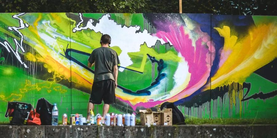 Graffiti ist das visuelle Element des Hip-Hop. Die Graffiti-Künstler malen bunte Gemälde mit Spraydosen.