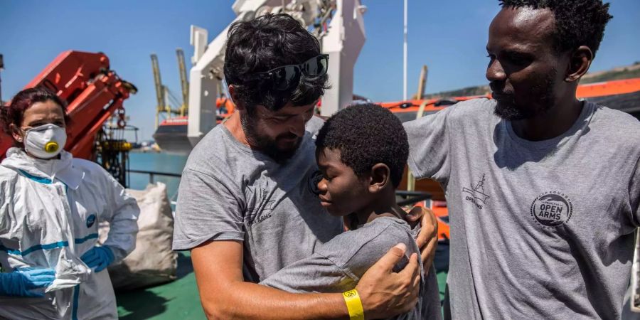 Ein Migrant verabschiedet sich nach der Ankunft auf dem Rettungsschiff «Open Arms» im Hafen von Barcelona von einem Helfer.