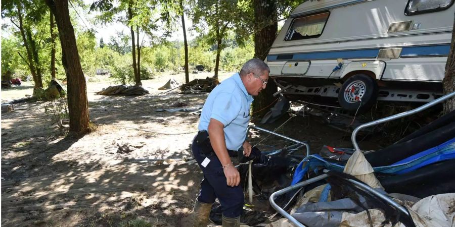 Ein Polizist untersucht einen durch Überschwemmungen beschädigten Wohnwagen in Südfrankreich.