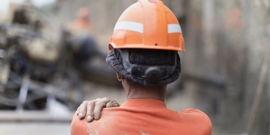 Bauarbeiter mit Helm vor Baustelle - Keystone