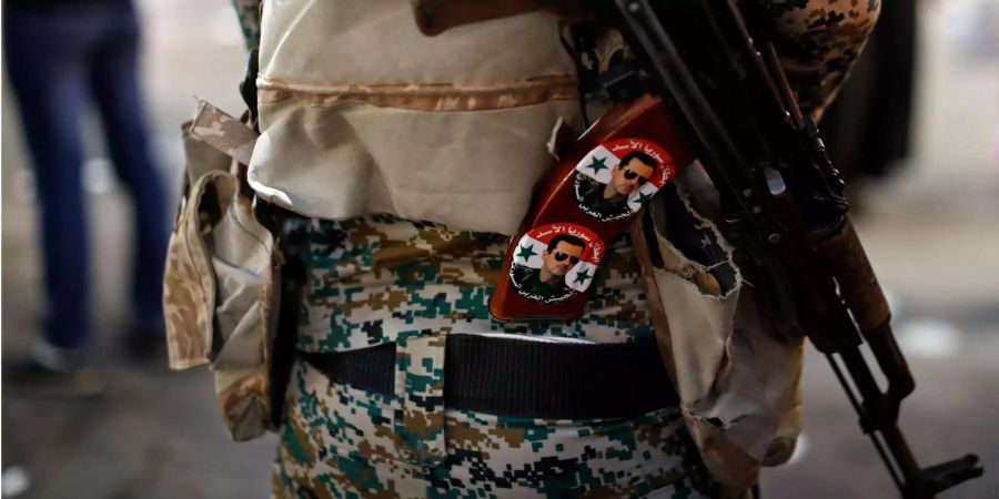 Ein syrischer Soldat mit Stickers von Assad an seiner Waffe.