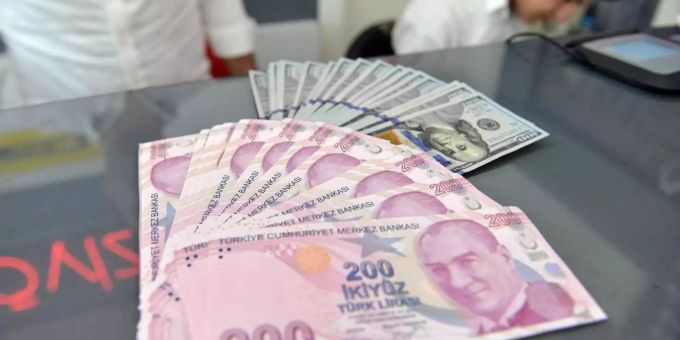 Ein Mitarbeiter einer Wechselstube zeigt türkische Lira und US-Dollar. Ein Mitarbeiter einer Wechselstube zeigt türkische Lira und US-Dollar.